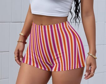 Puede incluir: Pantalones cortos de cintura alta con rayas verticales rosas, naranjas y blancas. Los pantalones cortos se combinan con un top corto blanco. El estilo es casual y veraniego.
