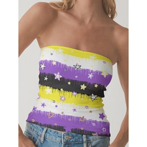 May include: A strapless tube top featuring a non-binary pride flag design. The top has horizontal stripes in yellow, white, purple, and black, adorned with star patterns. The garment is worn with blue denim jeans.