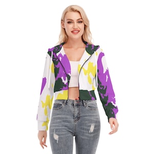 Op de afbeelding: Een witte, getailleerde hoodie met een rits. De hoodie heeft een kleurrijke, abstracte print in tinten paars, geel en groen.