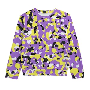 Pode incluir: Uma camisola de gola redonda com um padrão de camuflagem vibrante. O design apresenta formas irregulares em roxo, amarelo, preto e branco. A parte superior de manga comprida é feita de um material macio e é adequada para uso casual.