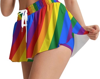 May include: Rainbow-striped shorts with a white drawstring. The shorts feature a vibrant pattern of diagonal stripes in the colors of the rainbow. The shorts have a flared skirt-like design.