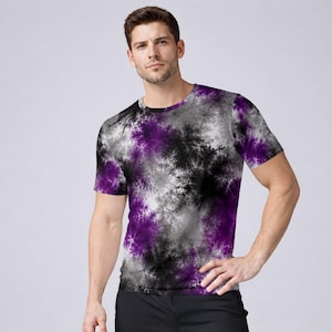 May include: A short-sleeved t-shirt featuring a vibrant, abstract fractal pattern in shades of deep purple, black, white, and grey. The garment has a classic crew neckline and a fitted silhouette, showcasing a complex, cloud-like design.