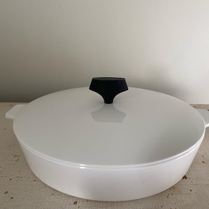 May include: White ceramic casserole dish with a black knob on the lid.