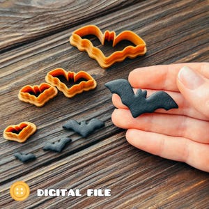 Pode incluir: Um conjunto de cortadores de biscoitos laranja em forma de morcego em três tamanhos diferentes, juntamente com três recortes pretos em forma de morcego. A imagem inclui o texto DIGITAL FILE em letras brancas no canto inferior esquerdo.