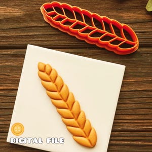 May include: An orange plastic wheat stalk cookie cutter and a corresponding tan wheat stalk shape pressed into a white square tile. The text "DIGITAL FILE" is printed in the bottom left corner of the white square tile in a rounded font.