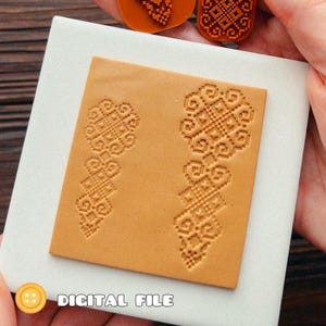 Puede incluir: Una pieza de cuero cuadrada de color tostado con dos patrones geométricos verticales en relieve con intrincados detalles de estilo punto de cruz. La superficie es lisa y de color marrón claro, mostrando un diseño simétrico repetitivo. El texto DIGITAL FILE es visible.