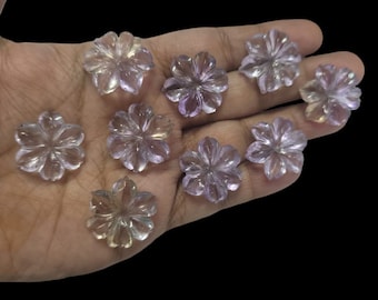 May include: Ten amethyst flower shaped cabochons, each with a five-petal design, in various shades of purple and clear.