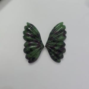 Peut inclure: Une paire d'ailes de papillon en pierre précieuse verte et violette avec un motif sculpté.