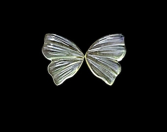 May include: A pair of translucent, pale yellow butterfly-shaped carvings made of a smooth, polished material. Each piece features delicate, radiating ridges that mimic the veins of wings, creating a symmetrical design with a soft, glossy finish.