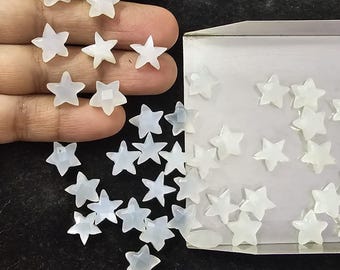 May include: A collection of white star-shaped beads, some are loose and others are in a white box. The box is open and the beads are visible. The text "Galaxy S24 Ultra" is visible in the bottom left corner of the image.