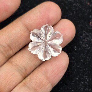 K&ouml;nnte beinhalten: Eine klare Quarzblumen-Schnitzerei mit einem f&uuml;nfblattartigen Design. Die Blume ist mit filigranen Details geschnitzt und hat eine glatte, polierte Oberfl&auml;che.