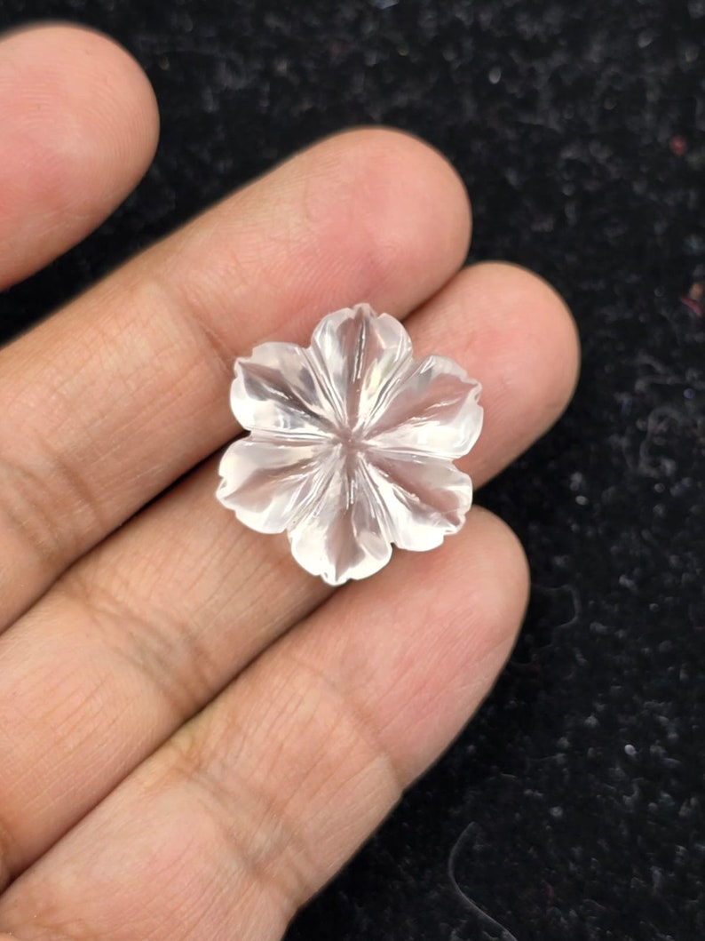 K&ouml;nnte beinhalten: Eine klare Quarzblumen-Schnitzerei mit einem f&uuml;nfblattartigen Design. Die Blume ist mit filigranen Details geschnitzt und hat eine glatte, polierte Oberfl&auml;che.