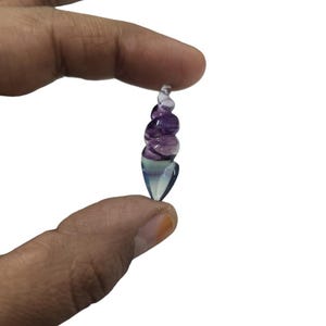 May include: A small, spiraled, purple and blue crystal pendant.