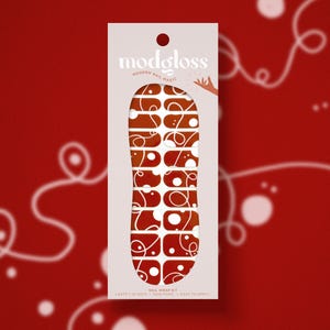 May include: A set of nail wraps with a red and white abstract design. The design features white circles and lines on a red background. The nail wraps are labeled "modgloss modern nail magic".