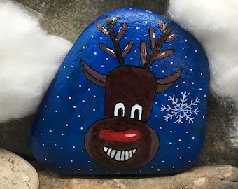 A rena de Natal (Rudolph) chegou. O motivo nº 2 sobre fundo azul-escuro chegou! "Arte de Seixo" pintada à mão sobre pedra natural.