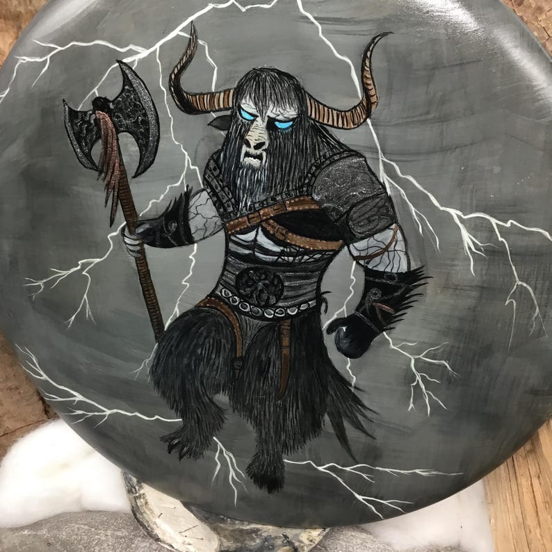 May include: A hand-painted illustration of a mythical creature with bull-like features, holding an axe. The creature is depicted with black fur, armour, and glowing blue eyes, set against a grey background with white lightning bolts.