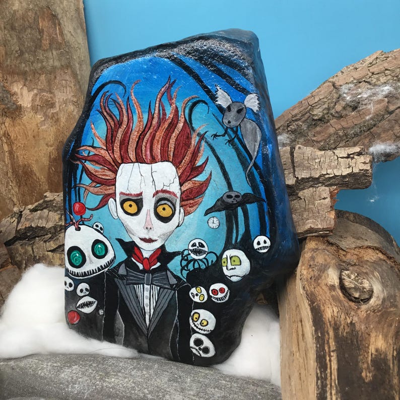 Pu&ograve; includere: Arte rupestre dipinta a mano raffigurante un personaggio con capelli rossi, un abito nero e un viso bianco con occhi gialli. Lo sfondo &egrave; blu con un pipistrello, un topo e altri personaggi spettrali.