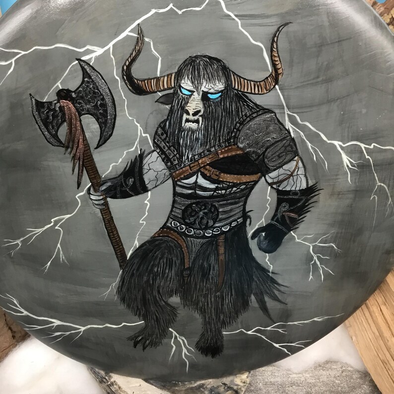 May include: A hand-painted illustration of a mythical creature with bull-like features, holding an axe. The creature has black fur, large horns, and blue eyes, set against a grey background with white lightning bolts.