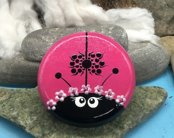 Ladybug ladybug is here. Dotted on a round Keraflot stone with 3D and glitter effects. Decorated in blackberry color.