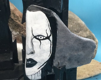 Marilyn Manson portrait, only the left side of the face, hand painted on a natural stone.