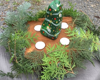 Advent wreath made from a wooden trunk with a Christmas Christ child/angel motif painted and immortalized on a natural stone.