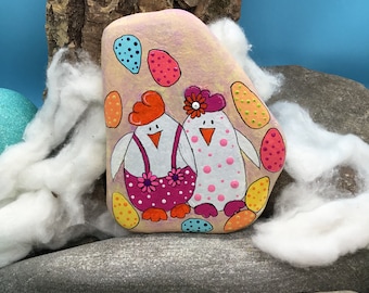 Two happy Easter chickens surrounded by Easter eggs wish Happy Easter, hand-painted on a flat natural stone.