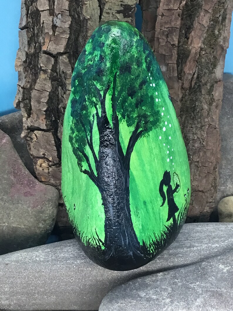 K&ouml;nnte beinhalten: Handbemalter Stein mit einer Darstellung eines gr&uuml;nen Baumes mit schwarzem Stamm und einer kleinen Figur, die davor steht. Der Hintergrund ist ein gr&uuml;ner Farbverlauf mit wei&szlig;en Punkten.