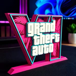 Puede incluir: Un letrero impreso en 3D con el logotipo de Grand Theft Auto V en rosa, turquesa y blanco. El letrero muestra el texto "grand theft auto" en blanco con bordes turquesa, sobre un fondo rosa en forma de V con siluetas de palmeras. Mide 17,91 cm de ancho, 11,81 cm de alto y 1,80 cm de profundidad.