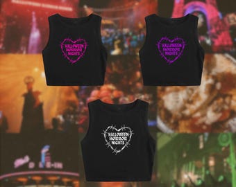 May include: Three black sleeveless crop tops featuring a graphic print of a heart shaped by barbed wire. Two tops display the text "HALLOWEEN HORROR NIGHTS" in purple, while the third top features the same text in white within the heart design.