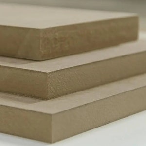 Puede incluir: Tres piezas de tablero de espuma beige apiladas una encima de la otra.