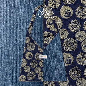 May include: A blue and gold fabric with a repeating pattern of stylised cranes and floral motifs. The fabric is textured and has a herringbone pattern.