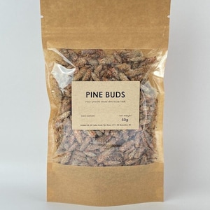 Könnte beinhalten: Ein brauner Papierbeutel mit einem durchsichtigen Plastikfenster, in dem getrocknete Kiefernknospen enthalten sind. Das Etikett lautet "PINE BUDS" und "Pinus sylvestris whole dried buds 100%". Das Etikett enthält auch "best before" und "net weight 50g".