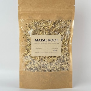 May include: A brown paper bag with a clear plastic window containing dried Maral Root. The bag has a label that reads "Maral Root" and includes the text "Rhodiola carthamoides cut and dried root 100%", "best before", and "net weight 100g".