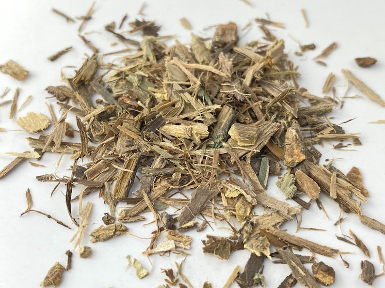 以下が含まれることがあります： 白い表面に置かれた、乾燥した薄茶色と緑色の植物質の塊。ハーブや根っこと思われる。