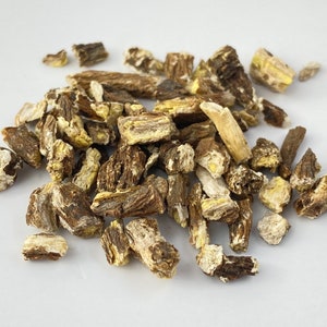 May include: A pile of dried, brown and yellow root pieces. The root pieces are irregularly shaped and have a rough texture.