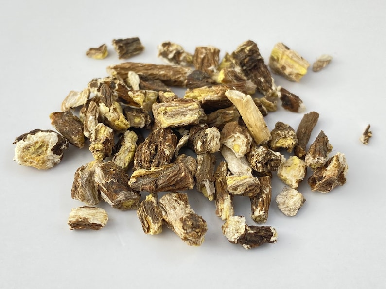 May include: A pile of dried, brown and yellow root pieces. The root pieces are irregularly shaped and have a rough texture.