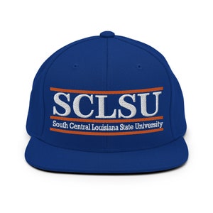 May include: A royal blue baseball cap with an orange and white embroidered logo that reads "SCLSU South Central Louisiana State University".