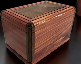 Peut inclure: Une boîte en bois avec un incrustation en bois foncé. La boîte est en bois de cèdre et a une finition en bois naturel.