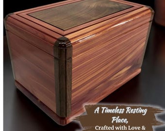 Peut inclure: Une boîte en bois avec un dessus en bois foncé et un corps en bois clair. La boîte est ornée d'une bordure en bois foncé autour des bords. La boîte est posée sur une surface sombre. Le texte "A Timeless Resting Place, Crafted with Love & Care" est écrit sur un fond brun dans le coin inférieur droit de l'image.