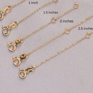 Może przedstawiać: Pięć złotych przedłużek do łańcuszka w różnych długościach: 2,5 cm, 3,8 cm, 5 cm, 6,3 cm i 7,6 cm.