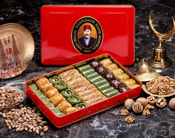 Puede incluir: Una caja de hojalata roja con una tapa dorada y una etiqueta dorada con el texto "Haci Ismail Hakkizade Hafiz Mustafa 1864" y una imagen de un hombre con un fez rojo. La caja está llena de baklava, un pastel turco tradicional.