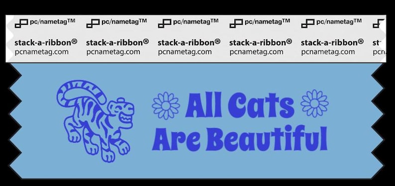 A light blue ribbon with a picture of a smiling tiger. The dark blue text to the right says, “All Cats Are Beautiful.” There are flowers around the text.