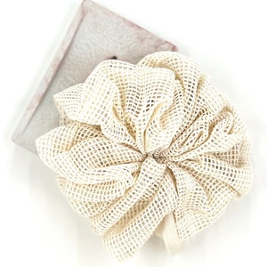 May include: A white mesh bath pouf, a soft and textured exfoliating sponge for the body.