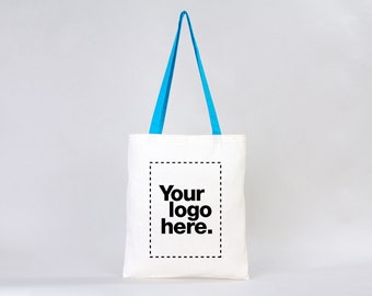 May include: White tote bag with blue handles. The bag has a black dashed line box with the text "Your logo here."