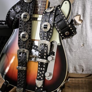 Correa de guitarra Glam Rock – Cuero negro grabado con tachuelas, conchos y hebilla – Hecha a mano en Italia