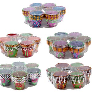 May include: Set of colourful, hand-painted, decorative candle holders. Each holder features intricate designs and a beaded trim. The holders are arranged in a circular pattern, with three rows of four holders each.