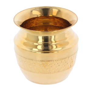 May include: A polished, gold-coloured metal pot with a wide, flared rim and a rounded body. The pot features a textured band of small, evenly spaced dots around the middle. The interior of the pot is visible and reflects light. The pot is likely for decorative or ceremonial use.