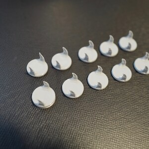 May include: Ten white plastic hooks with a curved design. The hooks are arranged in two rows of five.