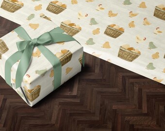 May include: A gift box wrapped in white paper with a green ribbon. The paper has a repeating pattern of yellow chicks and baskets of eggs.