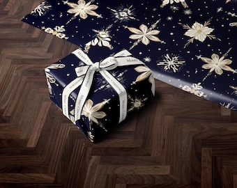 May include: A wrapped gift box and wrapping paper featuring a navy blue background with gold floral and snowflake designs. The gift box is tied with a white ribbon that reads "Merry Christmas". The items are on a dark wood surface.